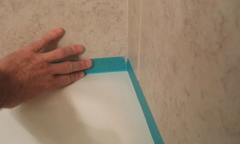 Dùng băng keo ở những đường kẻ góc mép tương của bồn tắm Dùng băng keo ở những đường kẻ góc mép tương của bồn tắm